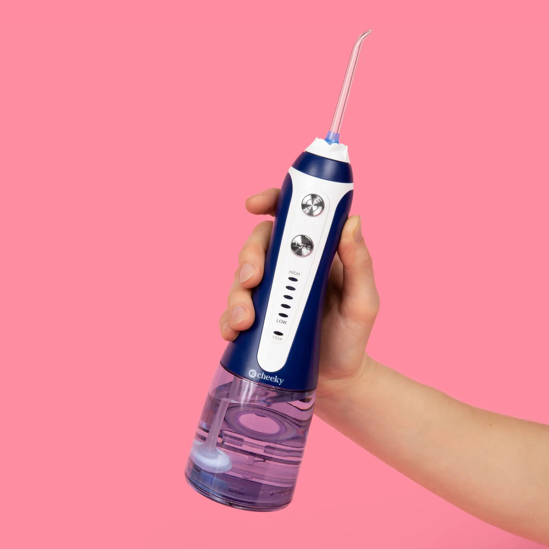 Hand holding a blue and white water flosser against a pink background